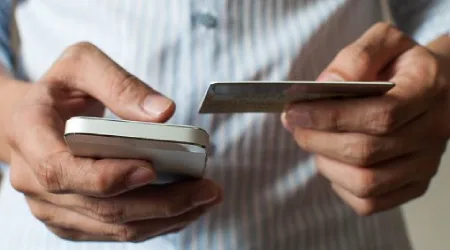 Person using a phone and card.